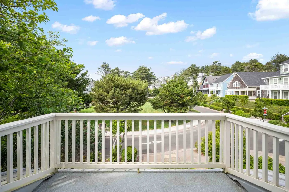 A serene balcony view overlooking a quiet street lined with trees. The balcony’s railing provides a safe spot to enjoy the outdoors, while the perspective hints at relaxing moments spent watching neighborhood life or unwinding after a day of exploring.