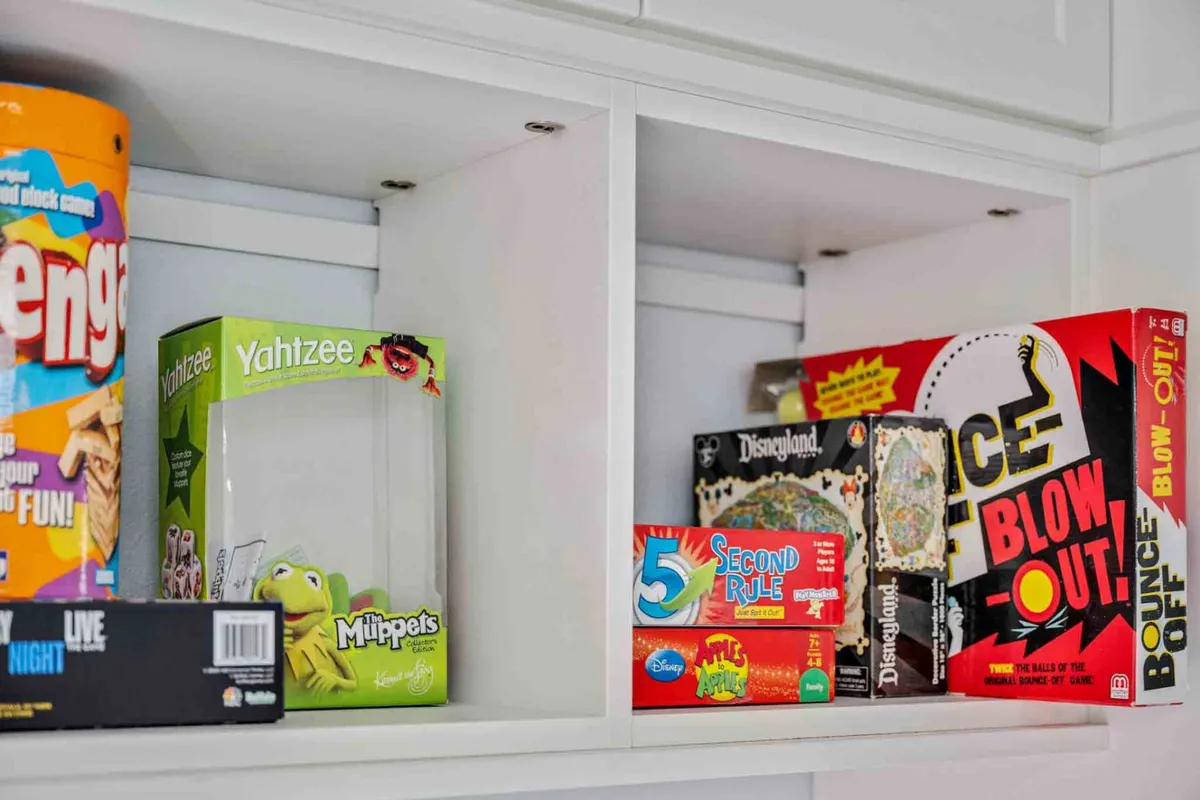 A vibrant collection of classic board games—Jenga, Yahtzee, Muppets, 5 Second Rule, Bounce Off—spread out on a table, inviting guests to come together for some friendly competition and laughter.