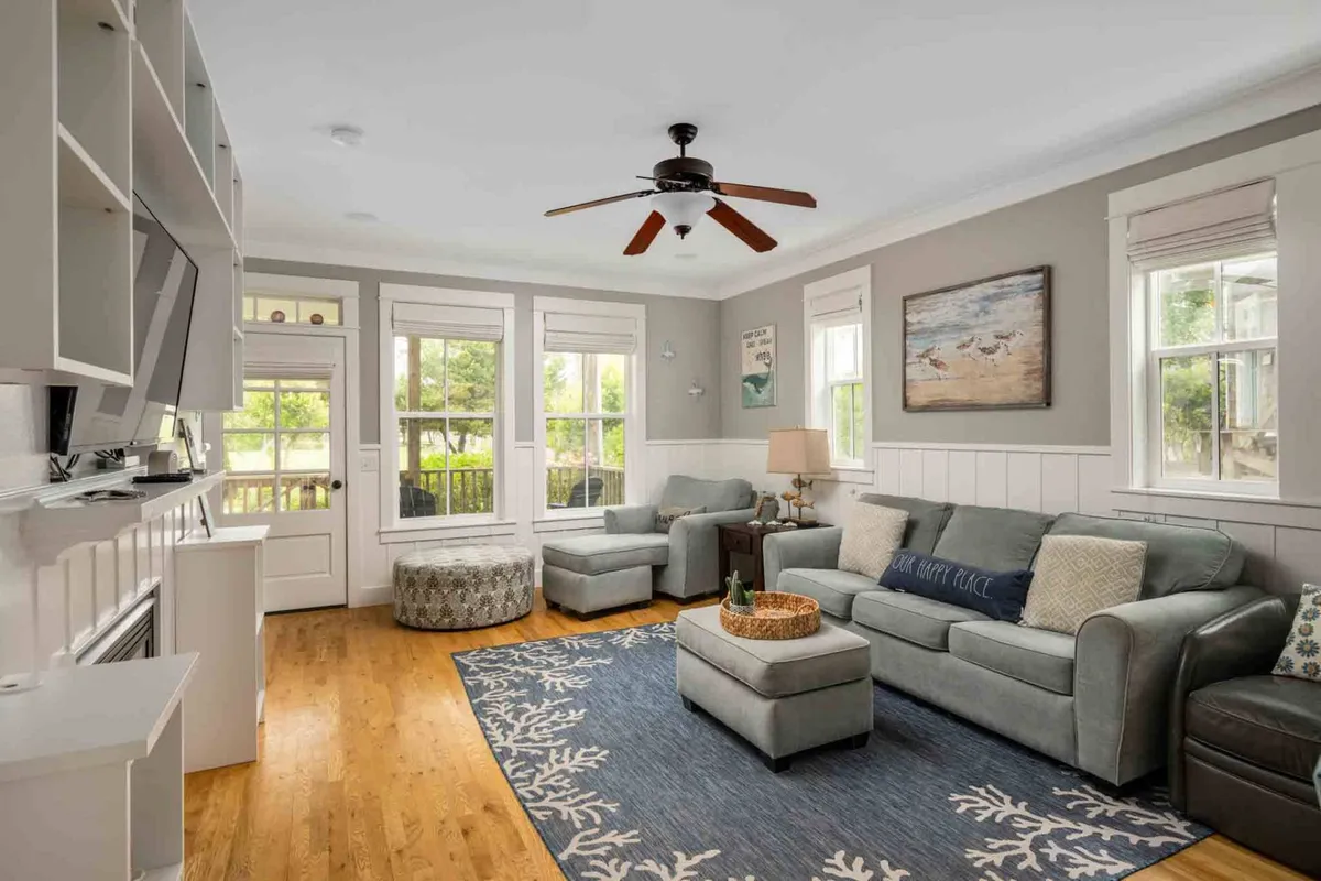 A cozy living room with a comfortable sofa, coffee table, TV, lamp, and tasteful artwork on the wall. The warm, welcoming ambiance suggests a space ideal for unwinding, reading, or connecting with family and friends in a peaceful setting.